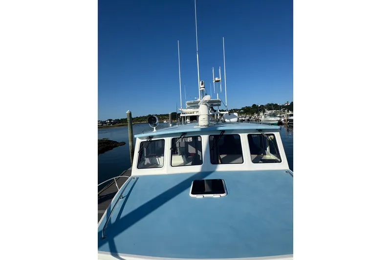 Slide: The Image of 2016 Young Brothers Downeast boat docked, featuring a blue cabin roof and multiple antennas. - 9