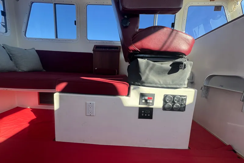 Slide: The Image of Interior of a 2016 Young Brothers Downeast boat with red seating and control panel. - 24