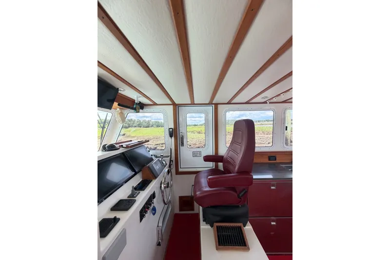 Slide: The Image of Interior of 2016 Young Brothers Downeast boat with red captain's chair and navigation equipment. - 17
