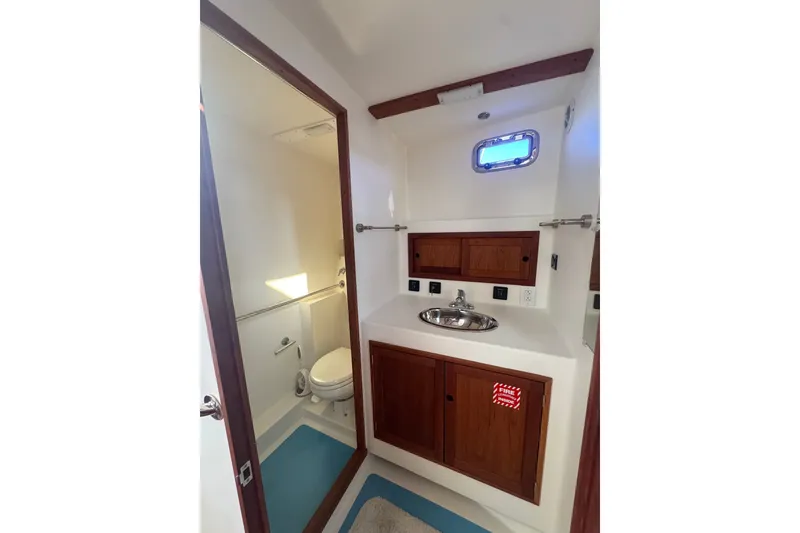 Slide: The Image of 2016 Young Brothers Downeast boat bathroom with wooden cabinets and stainless steel sink. - 23