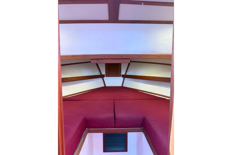 Slide: The Image of Interior cabin of 2016 Young Brothers Downeast boat with red cushions and wooden accents. - 32