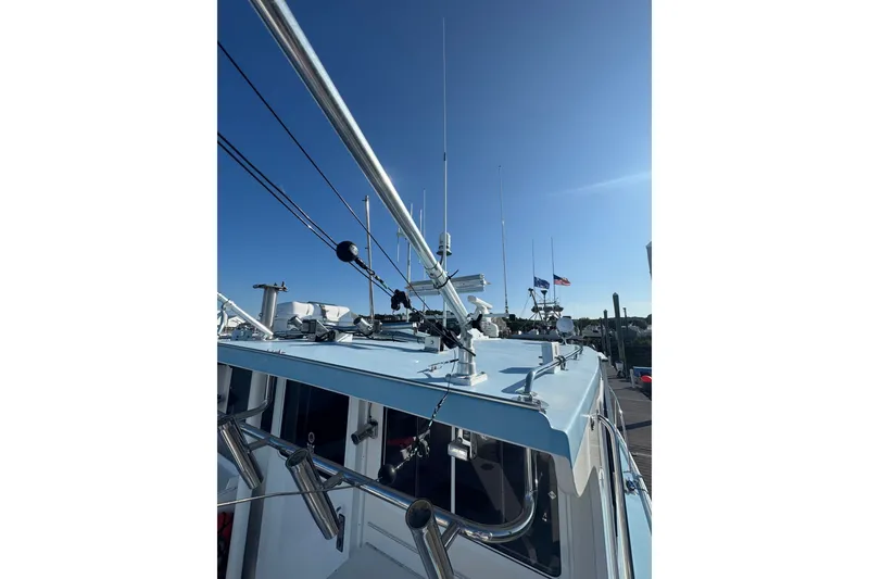 Slide: The Image of 2016 Young Brothers Downeast boat with antennas and flags under clear blue sky. - 10