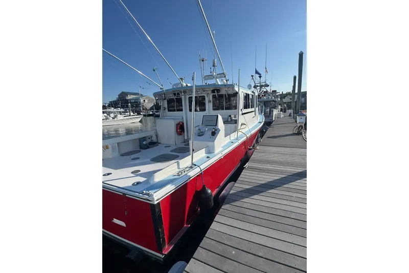 Slide: The Image of Red 2016 Young Brothers Downeast boat docked at a marina under clear blue skies. - 4