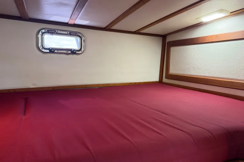 Slide: The Image of Cozy cabin interior of 2016 Young Brothers Downeast boat with red bedding. - 27