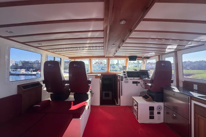 Slide: The Image of Interior of 2016 Young Brothers Downeast boat with red seating and navigation equipment. - 12