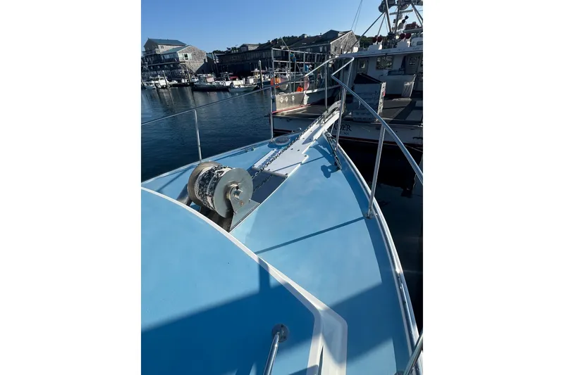 Slide: The Image of 2016 Young Brothers Downeast boat docked, featuring a blue deck and winch system. - 11