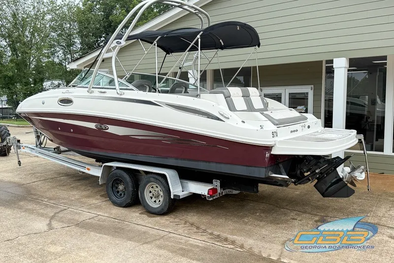 Slide: The Image of 2011 Sea Ray 260 Sundeck boat on trailer, featuring sleek design and bimini top. - 14