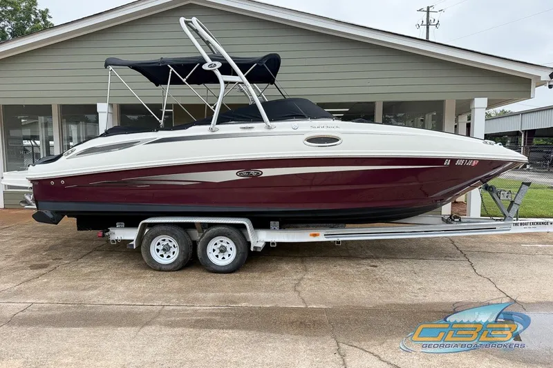 Slide: The Image of 2011 Sea Ray 260 Sundeck boat on trailer, parked outside a building. - 0