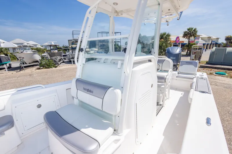 Slide: The Image of 2012 Everglades 243 Center Console boat with sleek design, parked outdoors under clear skies. - 36