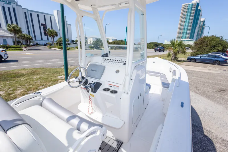 Slide: The Image of 2012 Everglades 243 Center Console boat with modern helm, parked near urban buildings. - 20