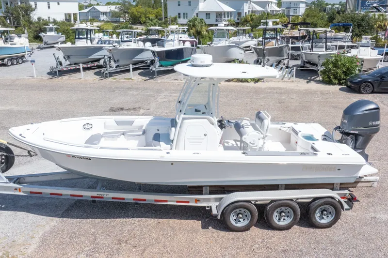 Slide: The Image of 2012 Everglades 243 Center Console boat on trailer, parked in a marina lot. - 3