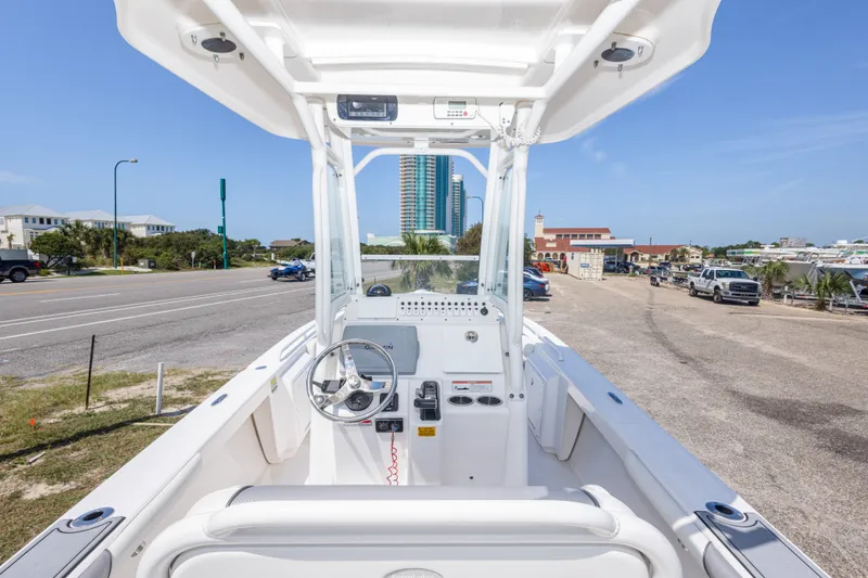 Slide: The Image of 2012 Everglades 243 Center Console boat at marina, showcasing helm and coastal surroundings. - 23