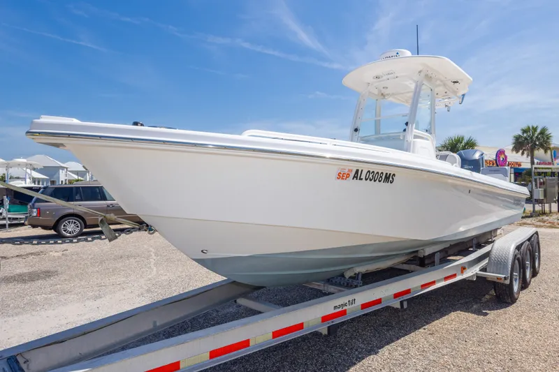Slide: The Image of 2012 Everglades 243 Center Console boat on trailer, parked outdoors under clear sky. - 15