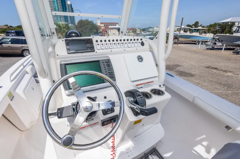Slide: The Image of 2012 Everglades 243 Center Console boat dashboard with steering wheel and navigation equipment. - 25