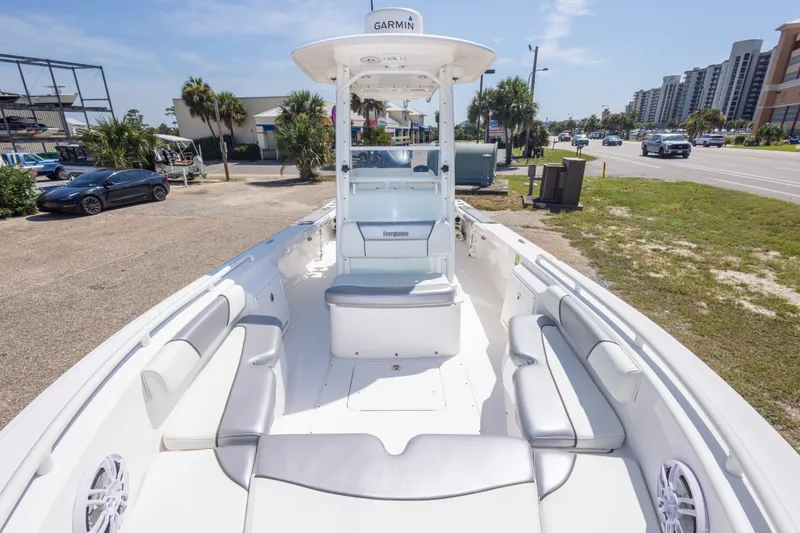 Slide: The Image of 2012 Everglades 243 Center Console boat with spacious seating, parked near a coastal road. - 32