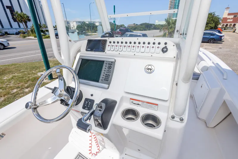 Slide: The Image of 2012 Everglades 243 Center Console boat dashboard with steering wheel and navigation controls. - 24
