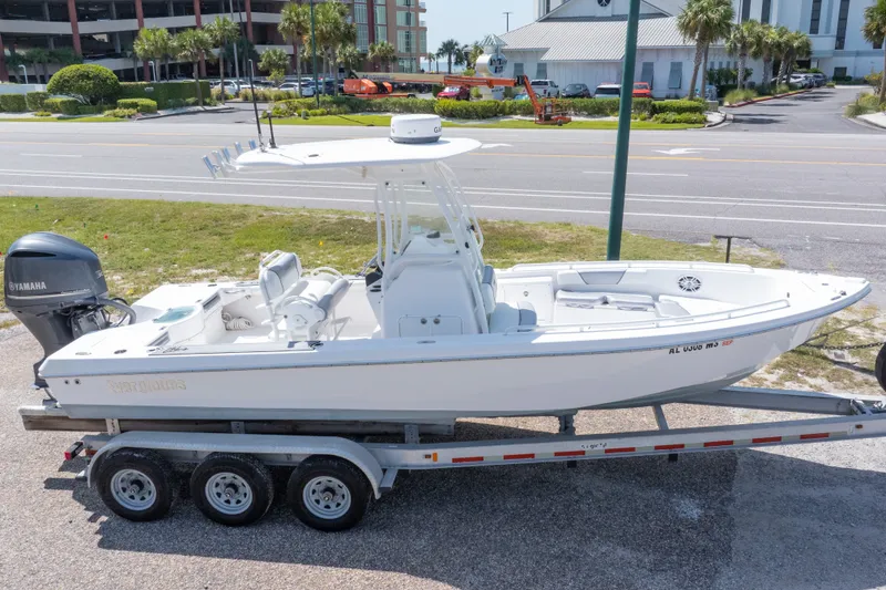 Slide: The Image of 2012 Everglades 243 Center Console boat on trailer, parked near a road. - 2