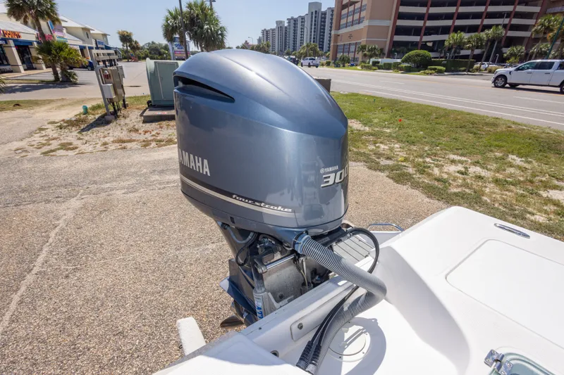 Slide: The Image of Yamaha 300 outboard motor on 2012 Everglades 243 Center Console boat, parked near a road. - 44
