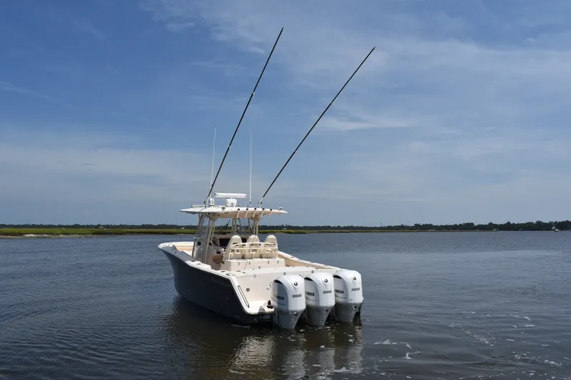Slide: The Image of 2019 Grady-White Canyon 336 boat with triple Yamaha engines on calm water. - 3