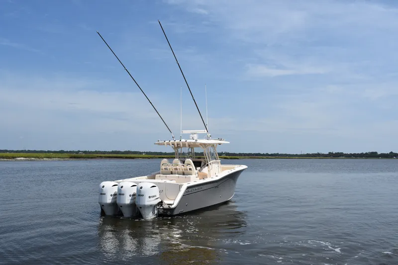 Slide: The Image of 2019 Grady-White Canyon 336 boat with triple Yamaha engines on calm water. - 5