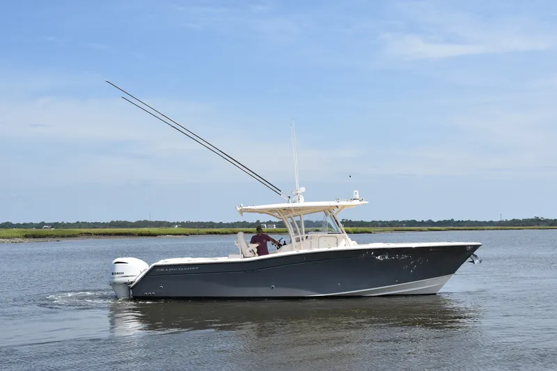 Slide: The Image of 2019 Grady-White Canyon 336 boat cruising on calm waters under a clear sky. - 7