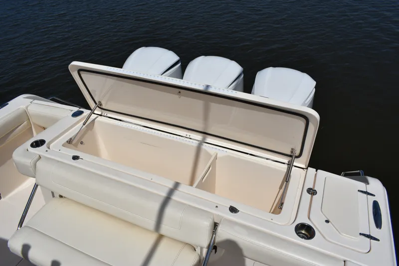 Slide: The Image of 2019 Grady-White Canyon 336 boat with open storage compartment and triple outboard motors. - 23