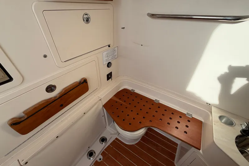 Slide: The Image of Interior of 2019 Grady-White Canyon 336 boat, featuring wooden accents and storage compartments. - 42
