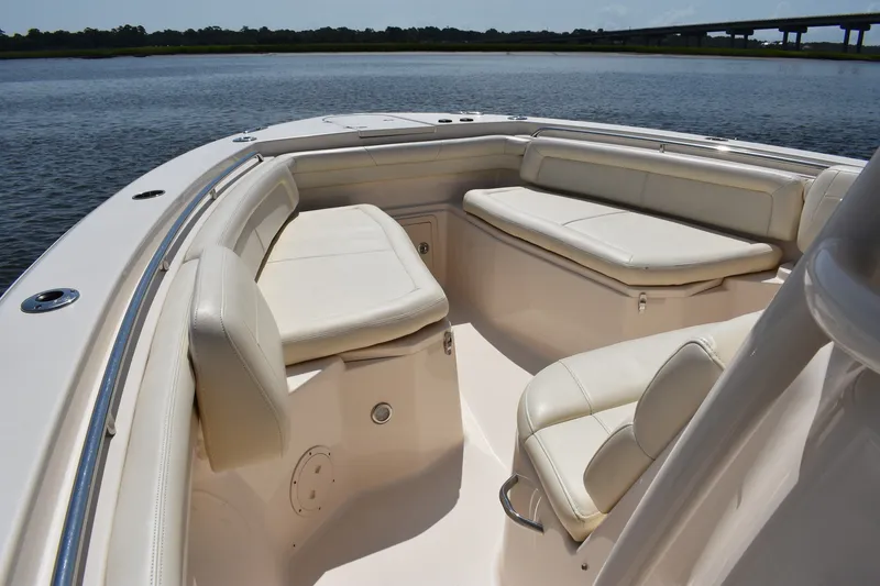 Slide: The Image of 2019 Grady-White Canyon 336 boat interior with cushioned seating on calm water. - 15