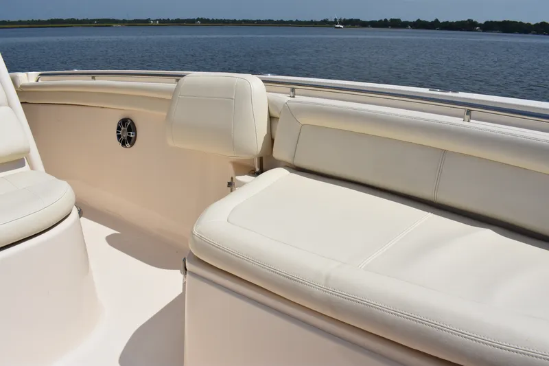 Slide: The Image of 2019 Grady-White Canyon 336 boat interior with white cushioned seating by the water. - 35