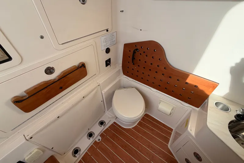 Slide: The Image of 2019 Grady-White Canyon 336 boat interior with toilet and wooden accents. - 43