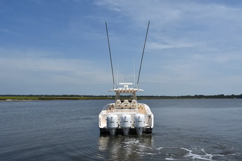Slide: The Image of 2019 Grady-White Canyon 336 boat on calm water, rear view with triple engines. - 4