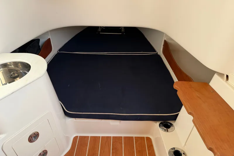 Slide: The Image of 2019 Grady-White Canyon 336 cabin interior with blue cushions and wooden accents. - 45