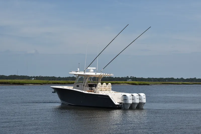 Slide: The Image of 2019 Grady-White Canyon 336 boat with triple Yamaha engines on calm water. - 2