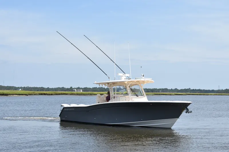Slide: The Image of 2019 Grady-White Canyon 336 boat cruising on calm waters under a clear sky. - 8