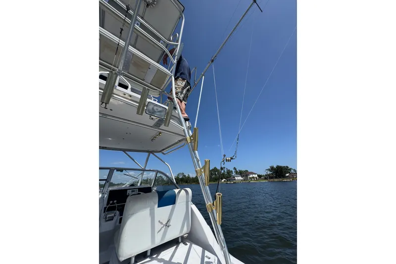Slide: The Image of 2003 PROLINE 33 Express boat with fishing gear, ladder, and scenic water view. - 20