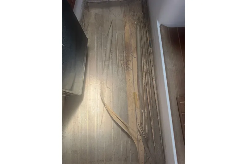 Slide: The Image of Damaged flooring on 2003 PROLINE 33 Express boat, showing wear and peeling. - 4