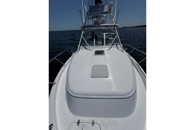 Slide: The Image of 2003 PROLINE 33 Express boat on water, showcasing deck and tower structure. - 11