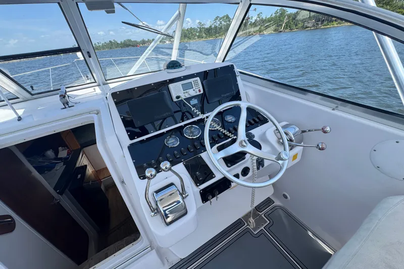 Slide: The Image of 2003 PROLINE 33 Express boat cockpit with steering wheel and control panel on water. - 23