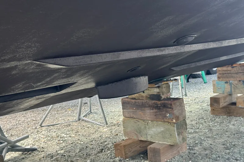 Slide: The Image of 2003 PROLINE 33 Express boat hull on wooden blocks, showcasing underside details. - 39