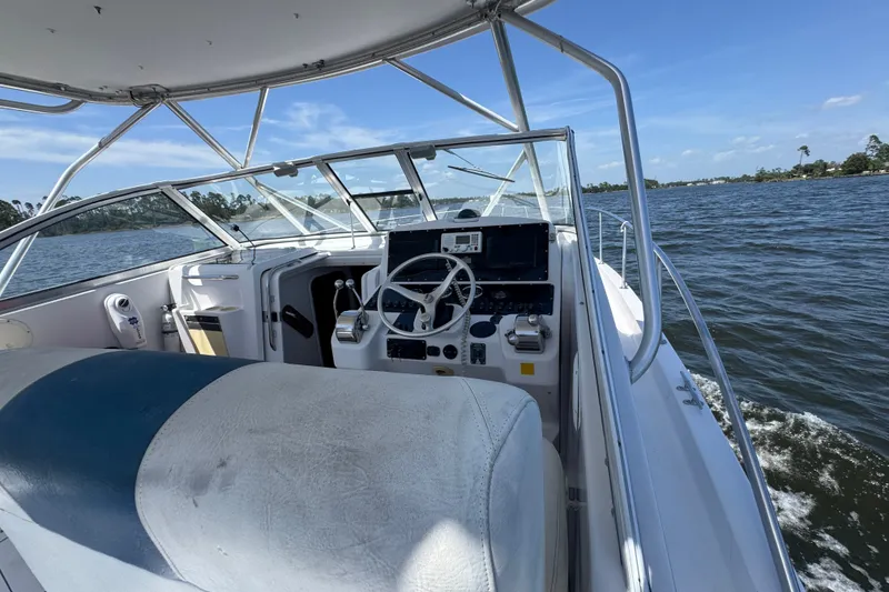 Slide: The Image of 2003 PROLINE 33 Express boat interior with steering wheel, dashboard, and water view. - 8