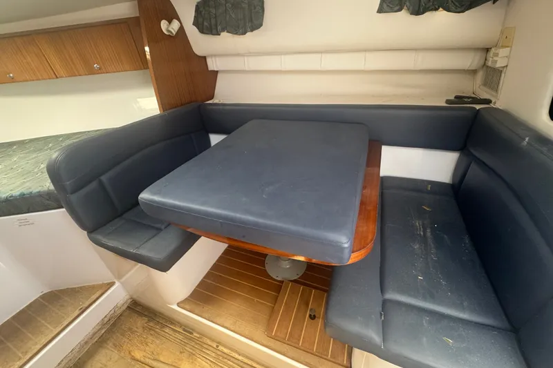 Slide: The Image of Interior of 2003 PROLINE 33 Express boat with cushioned seating and wooden table. - 7
