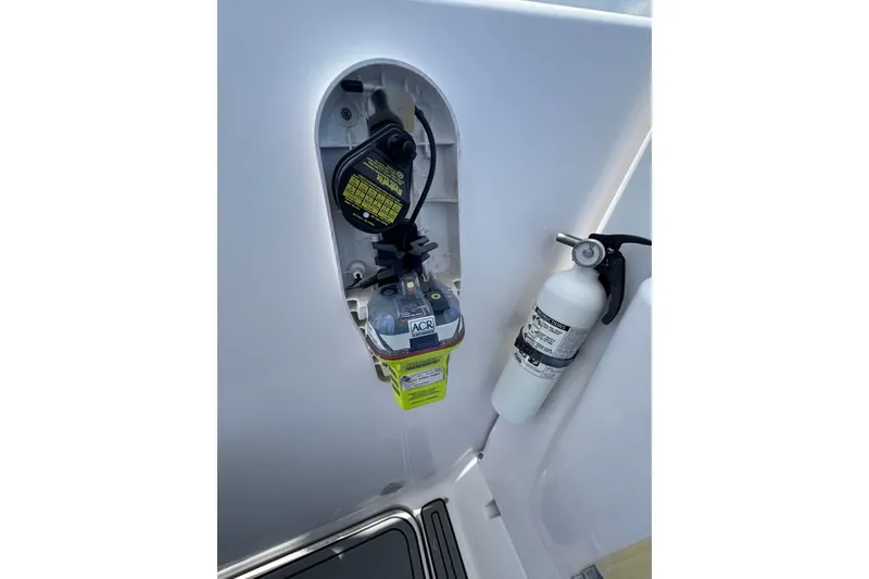 Slide: The Image of 2003 PROLINE 33 Express boat safety equipment, featuring an ACR device and fire extinguisher. - 26
