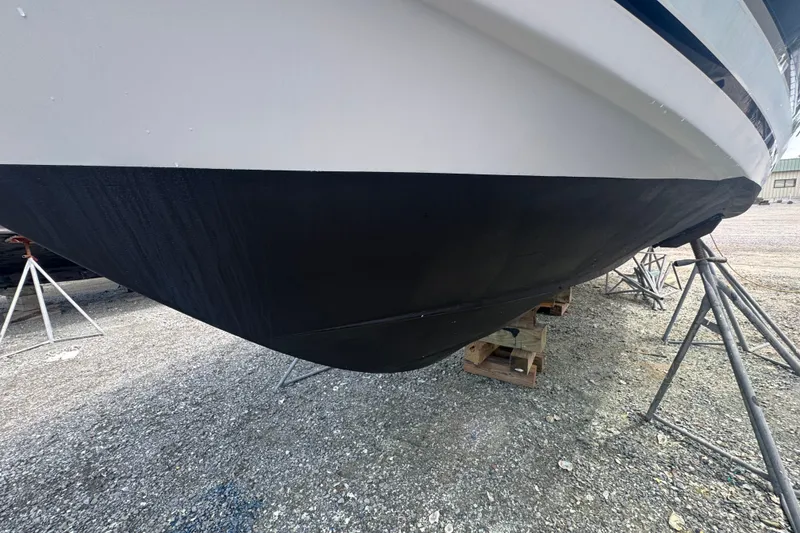 Slide: The Image of 2003 PROLINE 33 Express boat hull on stands, displayed outdoors. - 42