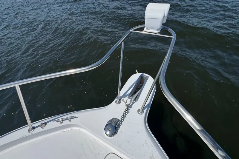 Slide: The Image of Bow of 2003 PROLINE 33 Express boat with anchor and railing on water. - 10