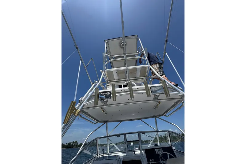 Slide: The Image of 2003 PROLINE 33 Express boat with tower, viewed from below against a clear blue sky. - 19