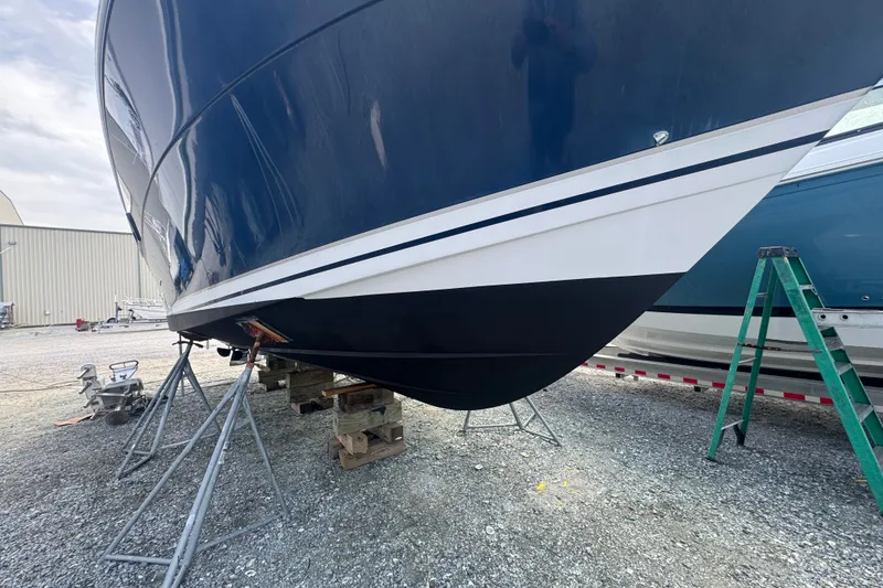 Slide: The Image of 2003 PROLINE 33 Express boat on stands, blue hull, outdoor storage. - 40
