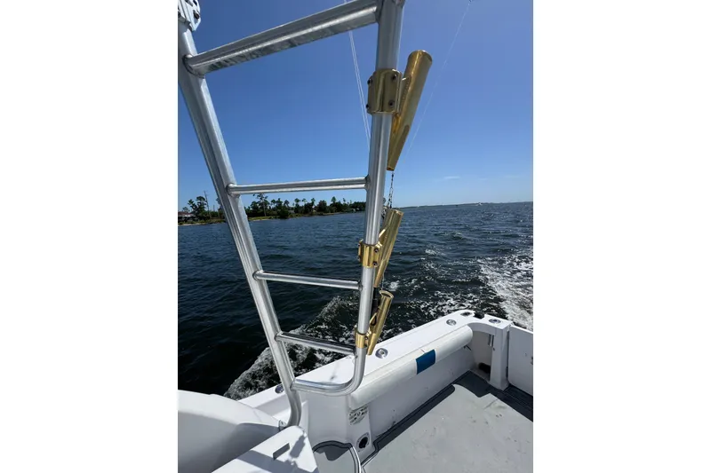 Slide: The Image of 2003 PROLINE 33 Express boat on water, featuring ladder and rod holders. - 17