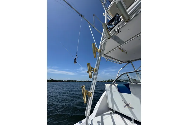 Slide: The Image of 2003 PROLINE 33 Express boat with fishing rod holders on a sunny day. - 18