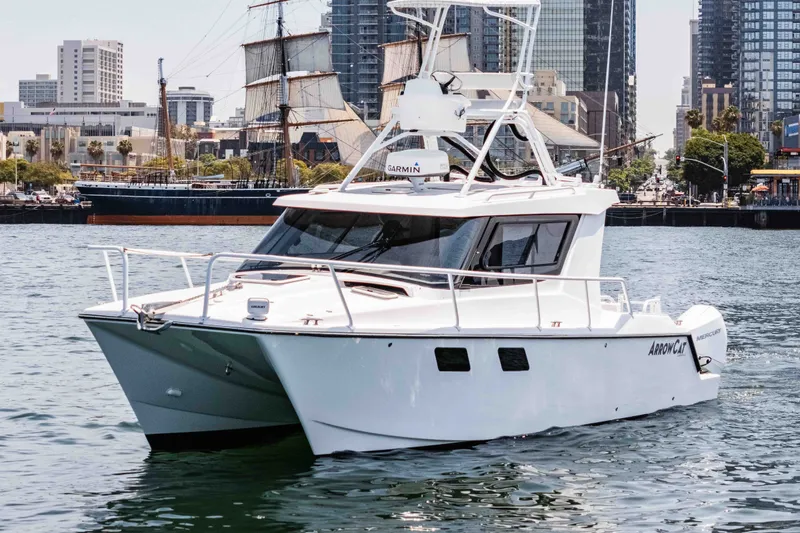 Slide: The Image of 2021 ArrowCat 320 boat cruising in urban harbor with city skyline backdrop. - 5