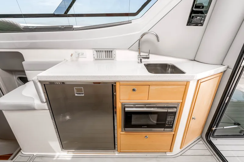 Slide: The Image of Compact galley kitchen in 2021 ArrowCat 320 boat with sink, fridge, and microwave. - 19